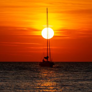 יאכטה ברקע שקיעה בים האדריאטי ותורן חוצה את השמש . קרואטיה